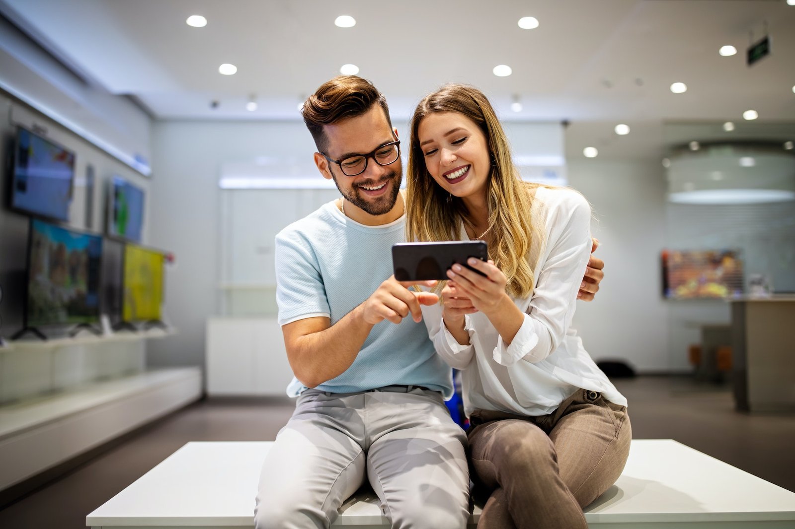 Happy couple enjoying social media content in a smart phone. Communication, connection concept.